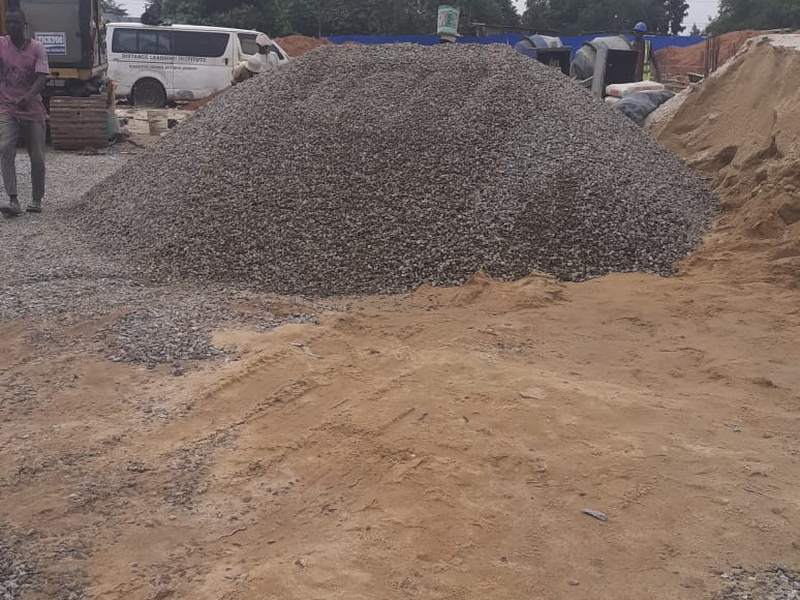 Granite chippings delivered to a building site beside a pile of sand
