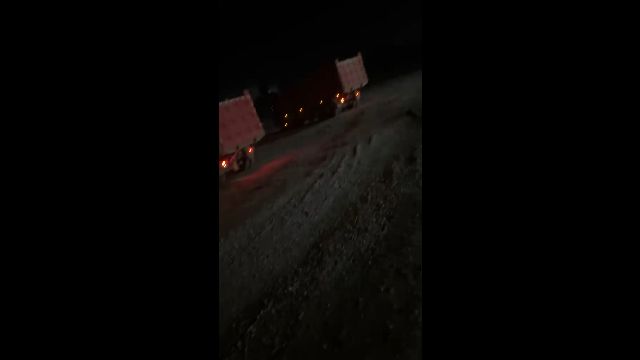 Trucks at a granite loading site after dark for a recorded bulk order